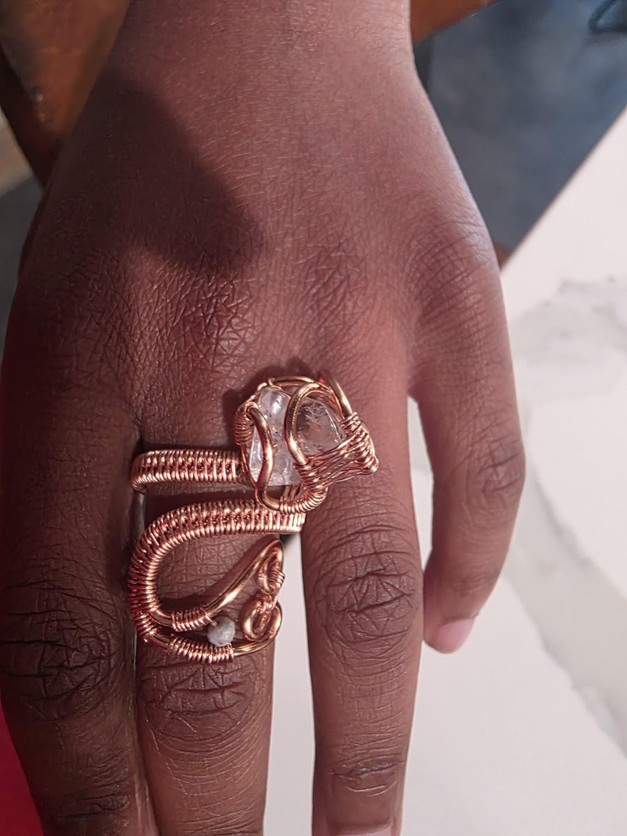 Hand-forged copper ring with clear quartz crystal, worn on hand
